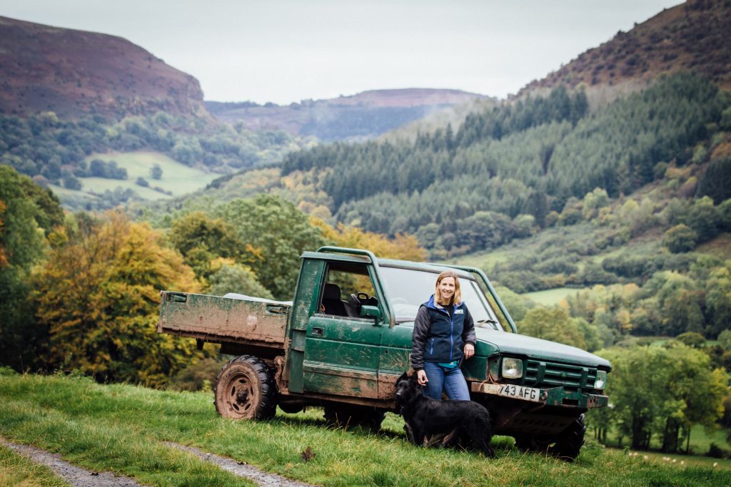 shepherdess with her 4x4 with the llanthony valley behind.